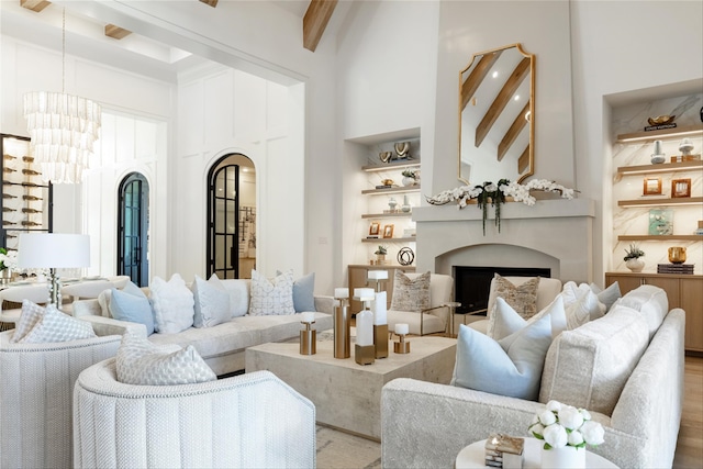 2300 Sorrelwood Ct, Celina, TX 75009 - living room featuring beamed ceiling, a towering ceiling, a fireplace, and arched walkways