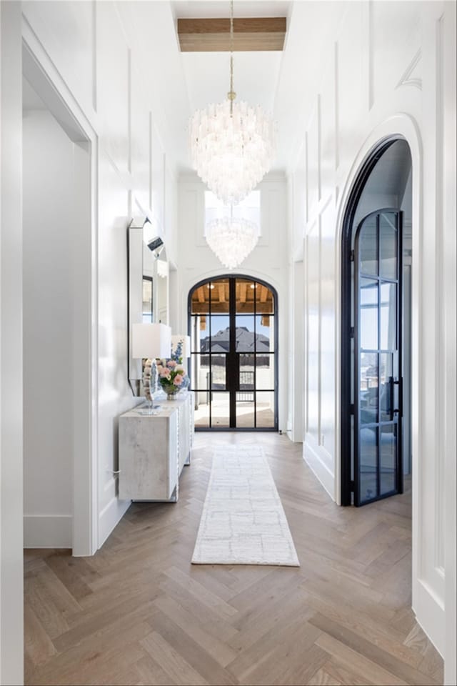 2300 Sorrelwood Ct, Celina, TX 75009 - entrance foyer featuring a chandelier, arched walkways, beam ceiling, a high ceiling, and baseboards