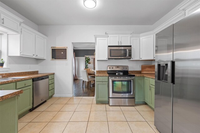 2923 Live Oak Ave, Waco, TX 76708 - kitchen featuring stainless steel appliances, green cabinetry, white cabinets, light tile patterned flooring, and a sink