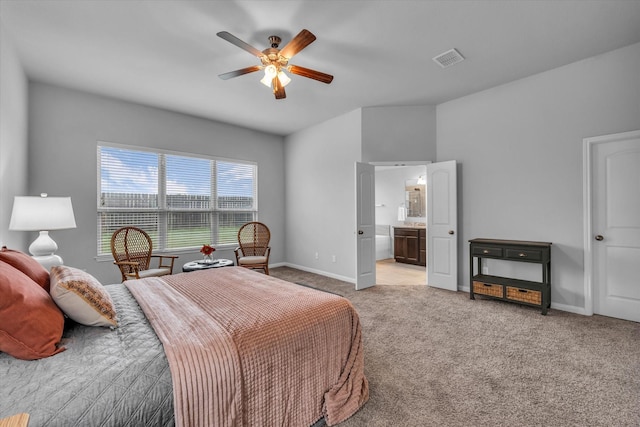 bedroom featuring light colored carpet, baseboards, a ceiling fan, and ensuite bathroom