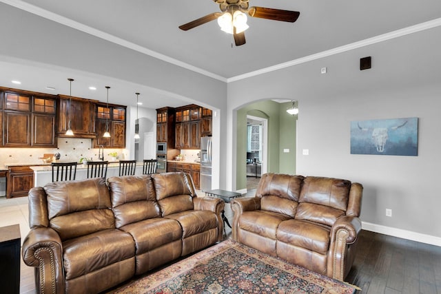 102 Willowbrook Dr, Waxahachie, TX 75165 - living area with arched walkways, a ceiling fan, baseboards, crown molding, and dark wood-style floors