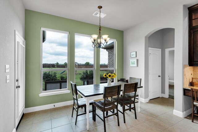 102 Willowbrook Dr, Waxahachie, TX 75165 - dining area with arched walkways, a chandelier, light tile patterned floors, and baseboards