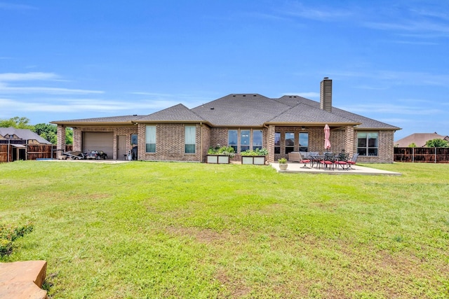102 Willowbrook Dr, Waxahachie, TX 75165 - back of property with an attached garage, a chimney, brick siding, and a patio area