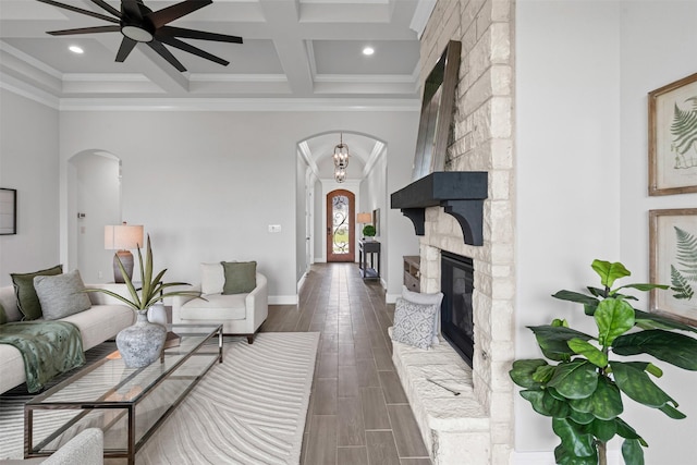 11612 Panther Dr, Godley, TX 76044 - living area featuring arched walkways, a ceiling fan, beam ceiling, dark wood-style flooring, and a fireplace