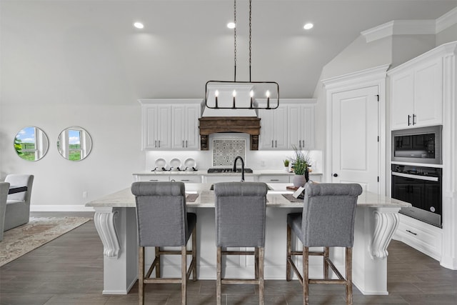 11612 Panther Dr, Godley, TX 76044 - kitchen featuring oven, built in microwave, an island with sink, lofted ceiling, and decorative backsplash
