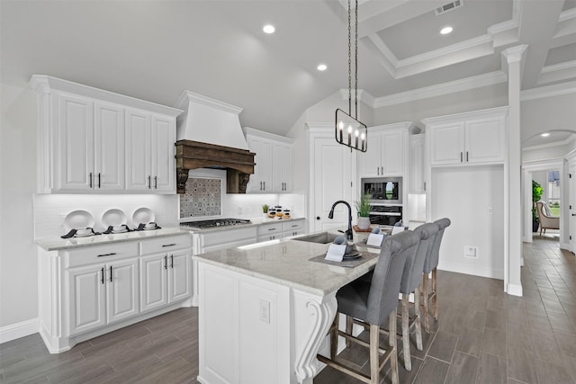 11612 Panther Dr, Godley, TX 76044 - kitchen featuring custom range hood, a sink, white cabinets, stainless steel appliances, and a kitchen island with sink