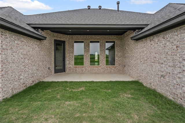 11612 Panther Dr, Godley, TX 76044 - doorway to property with a lawn, a shingled roof, brick siding, and a patio