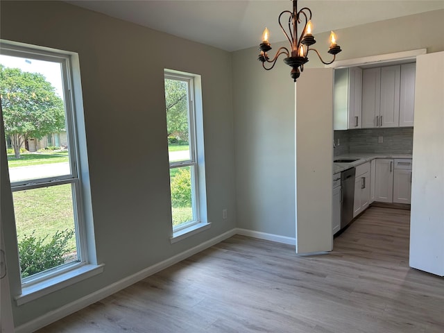 1104 Hillsdale Dr, Richardson, TX 75081 - kitchen with dishwasher, light wood-style floors, a chandelier, a sink, and baseboards
