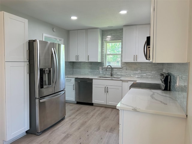 1104 Hillsdale Dr, Richardson, TX 75081 - kitchen with appliances with stainless steel finishes, a sink, light stone countertops, tasteful backsplash, and white cabinetry