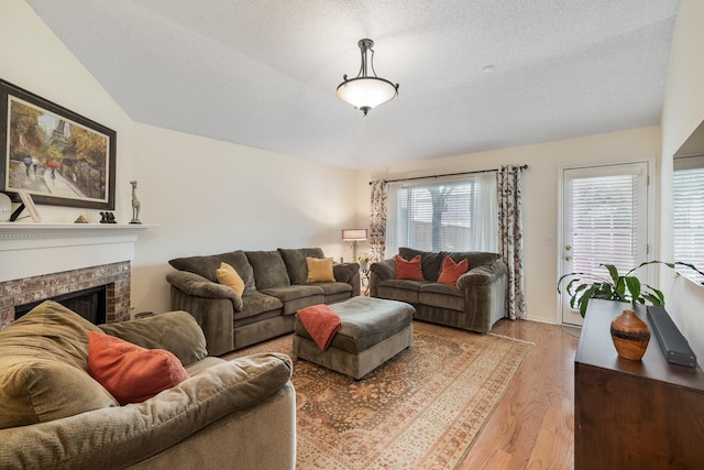 living room featuring wood finished floors, a fireplace, and a textured ceiling