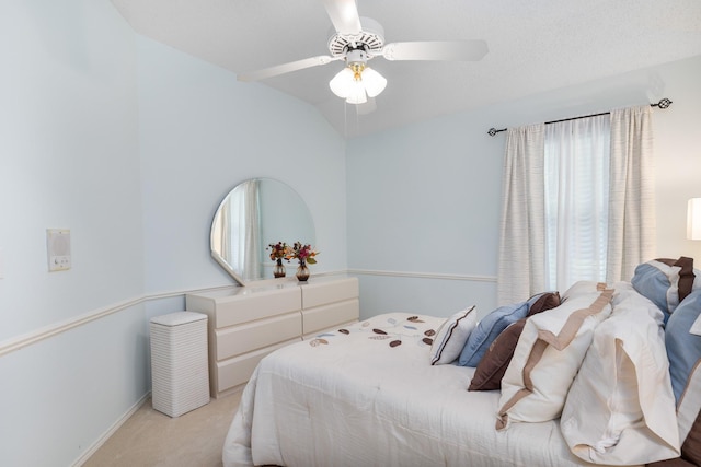 carpeted bedroom featuring lofted ceiling, a ceiling fan, and baseboards