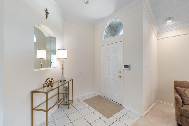 foyer entrance with ornamental molding, a textured ceiling, light tile patterned flooring, arched walkways, and baseboards