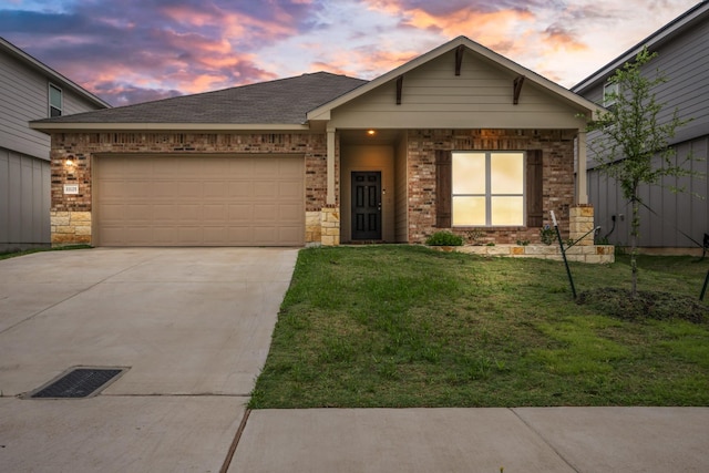 view of front of house with driveway, a garage, a front lawn, brick siding, and a shingled roof
