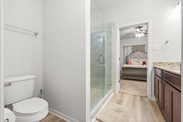 bathroom featuring ensuite bathroom, wood finished floors, a stall shower, ceiling fan, and toilet