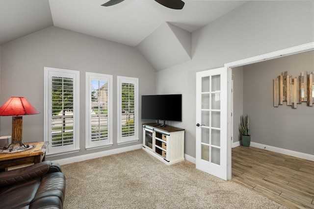 living area with vaulted ceiling, a ceiling fan, and baseboards