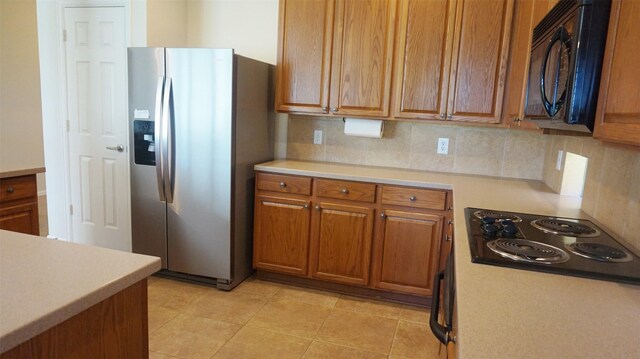 kitchen with black appliances, light countertops, and decorative backsplash