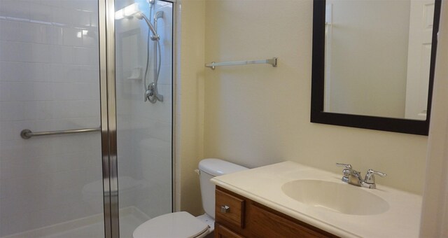 bathroom featuring a stall shower, toilet, and vanity