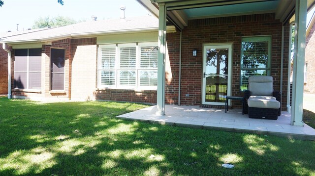 back of house with brick siding, a yard, and a patio
