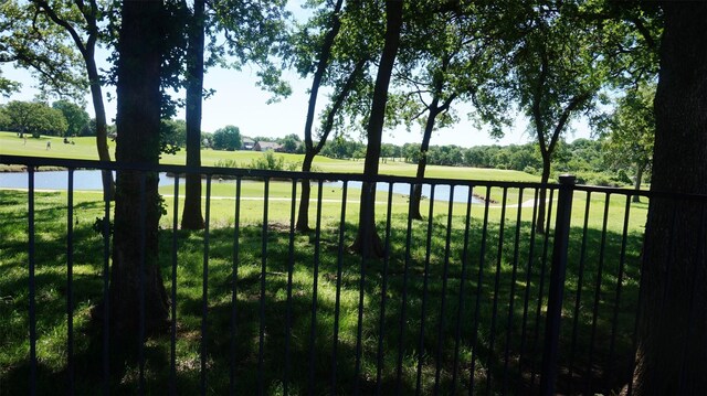 view of grassy yard featuring golf course view and a water view