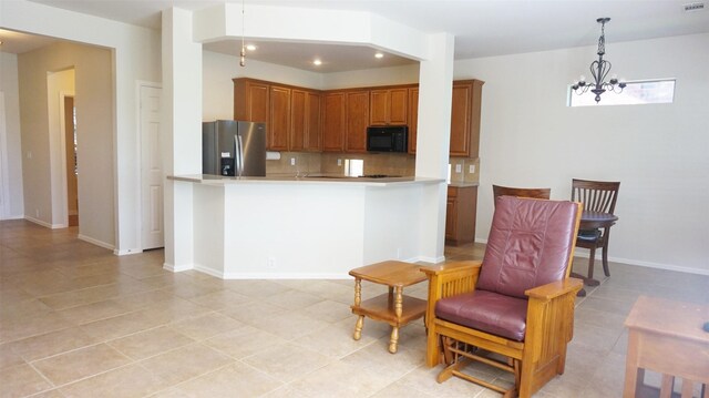 kitchen with black microwave, stainless steel fridge with ice dispenser, brown cabinetry, backsplash, and light countertops