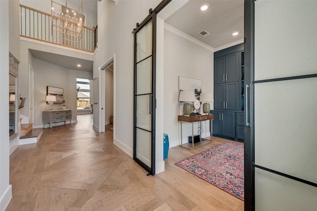 15102 Crape Myrtle Rd, Frisco, TX 75035 - foyer entrance featuring a barn door, baseboards, ornamental molding, a high ceiling, and a chandelier