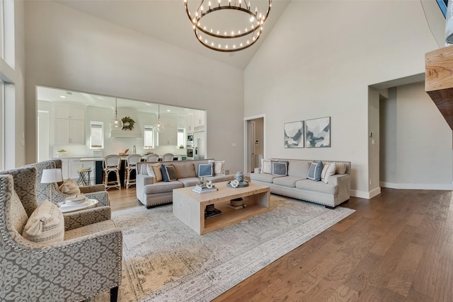 15102 Crape Myrtle Rd, Frisco, TX 75035 - living room featuring high vaulted ceiling, wood finished floors, a chandelier, and baseboards