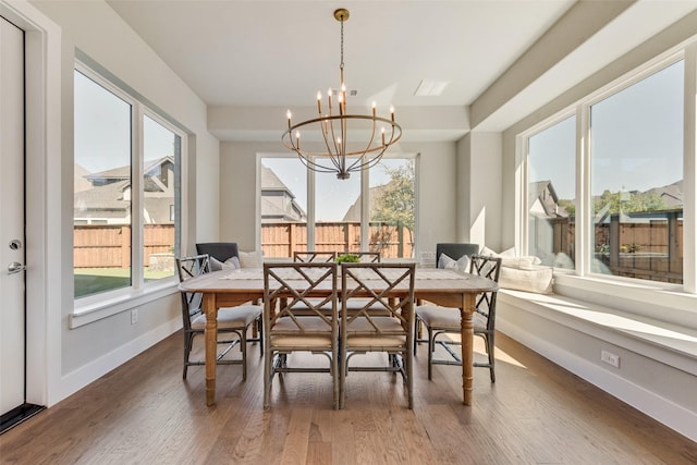dining area featuring a chandelier, plenty of natural light, and wood finished floors