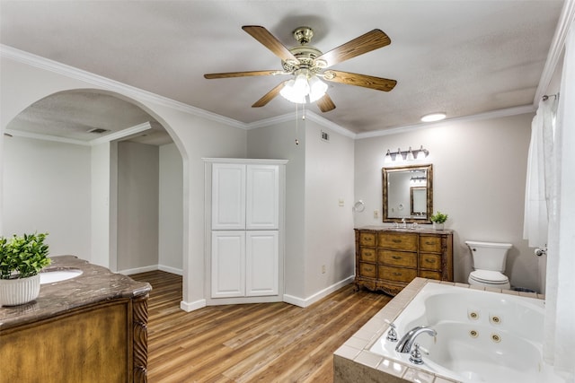 full bathroom with wood finished floors, ceiling fan, a jetted tub, two vanities, and baseboards