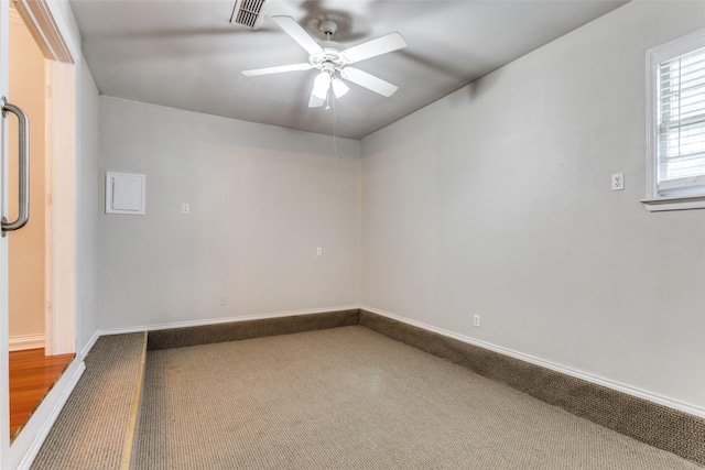 carpeted spare room with a ceiling fan and baseboards
