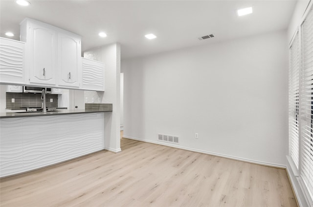 3022 Westforest Dr, Dallas, TX 75229 - kitchen with dark countertops, light wood-style floors, white cabinetry, recessed lighting, and baseboards