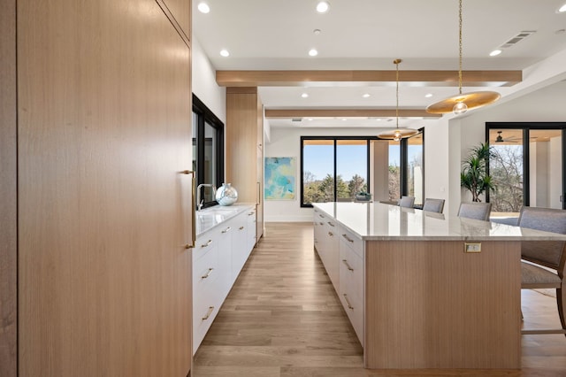 7115 Cast Iron Forest Trl, Colleyville, TX 76034 - kitchen with recessed lighting, modern cabinets, a breakfast bar, white cabinetry, and light wood-style floors