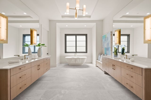 7115 Cast Iron Forest Trl, Colleyville, TX 76034 - full bath featuring a raised ceiling, a chandelier, a freestanding tub, two vanities, and recessed lighting