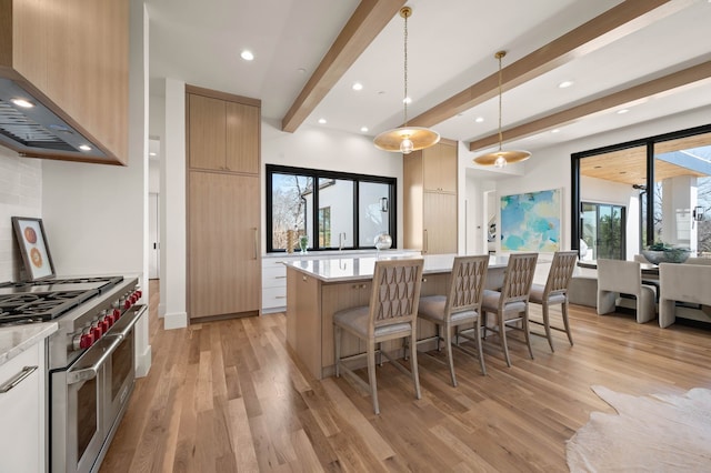 7115 Cast Iron Forest Trl, Colleyville, TX 76034 - kitchen with wall chimney exhaust hood, range with two ovens, modern cabinets, light wood-style flooring, and beamed ceiling