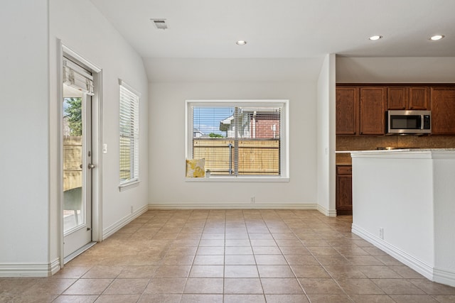 2912 Montalbo, Grand Prairie, TX 75054 - kitchen featuring stainless steel microwave, recessed lighting, light tile patterned floors, tasteful backsplash, and dark countertops