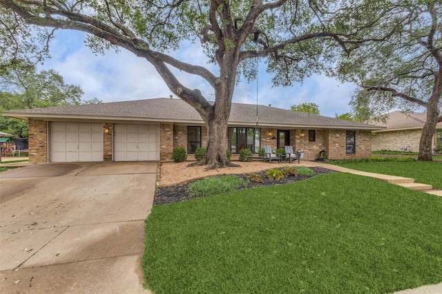 ranch-style house featuring brick siding, a garage, concrete driveway, and a front lawn