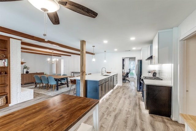 kitchen featuring a sink, light countertops, freestanding refrigerator, light wood-type flooring, and recessed lighting