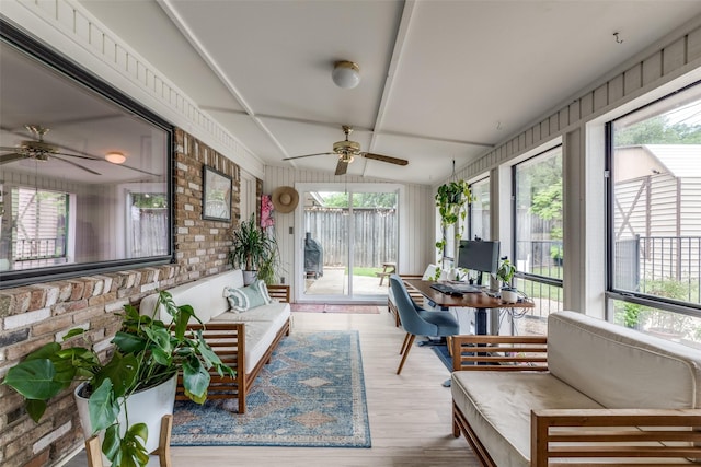 sunroom / solarium featuring a ceiling fan, an outdoor living space, plenty of natural light, and brick wall