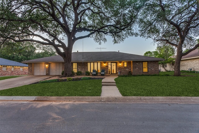 ranch-style house with a garage, driveway, and a front lawn