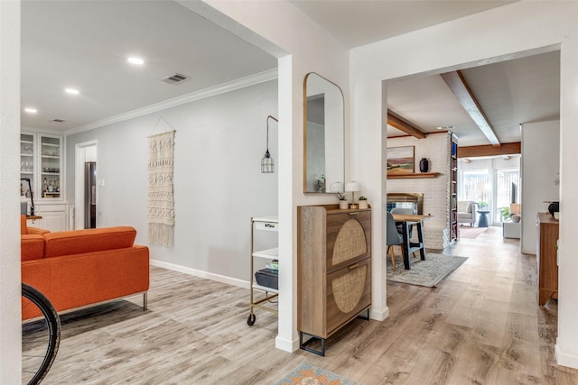 corridor with light wood finished floors, beam ceiling, baseboards, recessed lighting, and crown molding