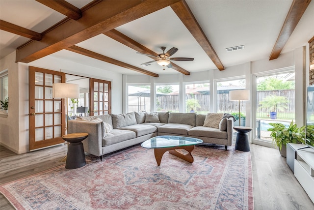 living area with wood finished floors, beamed ceiling, and ceiling fan