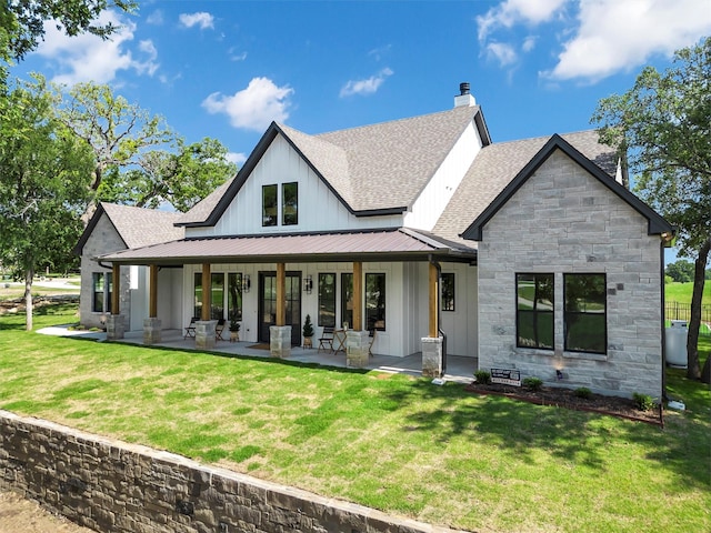 9001 Emma Ct, Granbury, TX 76049 - rear view of property with a shingled roof, a standing seam roof, stone siding, board and batten siding, and a lawn