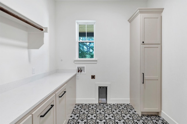 9001 Emma Ct, Granbury, TX 76049 - clothes washing area with hookup for an electric dryer, baseboards, cabinet space, light tile patterned floors, and hookup for a washing machine
