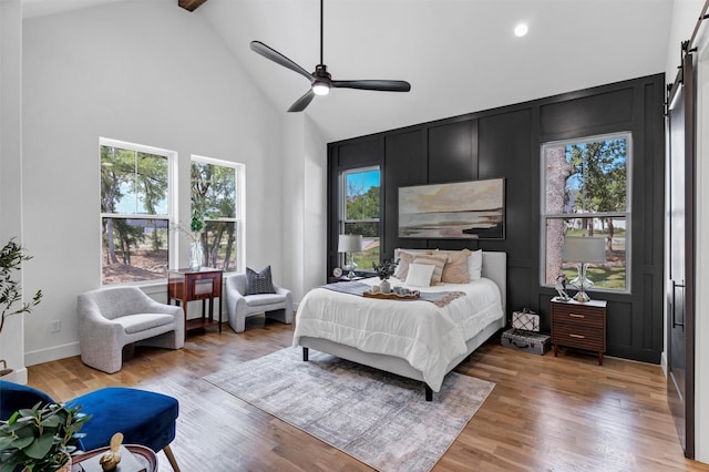 9001 Emma Ct, Granbury, TX 76049 - bedroom featuring a barn door, high vaulted ceiling, light wood finished floors, beam ceiling, and recessed lighting
