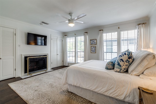 4229 Cole Ave Unit 115, Dallas, TX 75205 - bedroom featuring crown molding, dark wood finished floors, a fireplace, and a ceiling fan