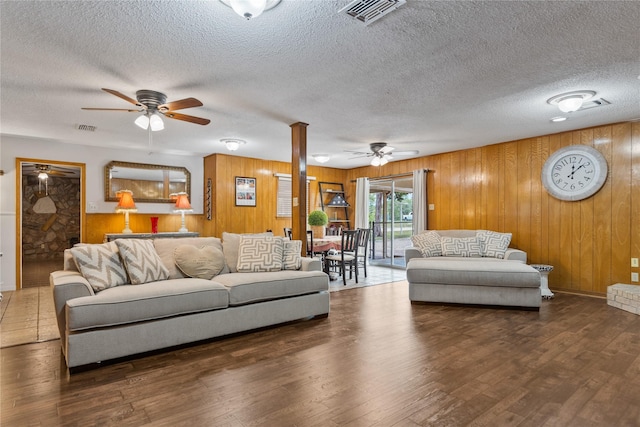 4325 Shady Glen Dr, Waco, TX 76708 - living room featuring a ceiling fan, wood walls, wood finished floors, and a textured ceiling