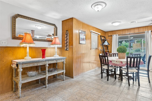 4325 Shady Glen Dr, Waco, TX 76708 - dining space featuring wooden walls, a textured ceiling, and baseboards