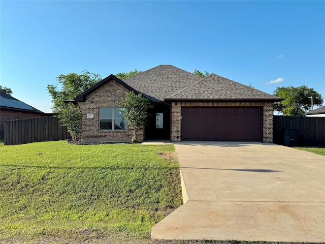 2004 Clay St, Mabank, TX 75147 - view of front facade featuring a garage, brick siding, a shingled roof, and driveway