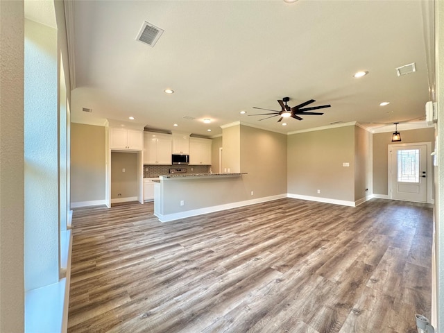 2004 Clay St, Mabank, TX 75147 - unfurnished living room featuring ornamental molding, recessed lighting, a ceiling fan, baseboards, and wood finished floors