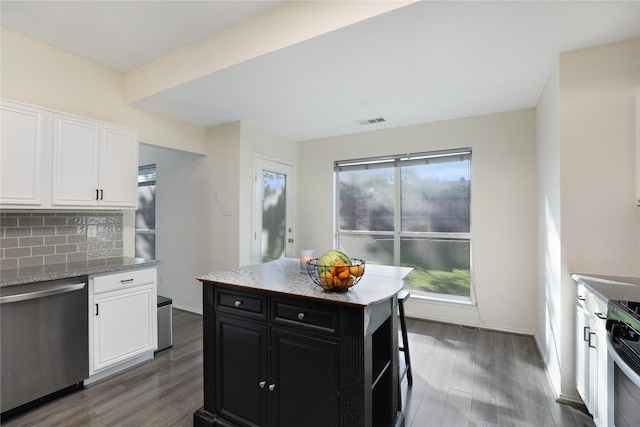 kitchen with stainless steel appliances, dark cabinetry, wood finished floors, and white cabinets