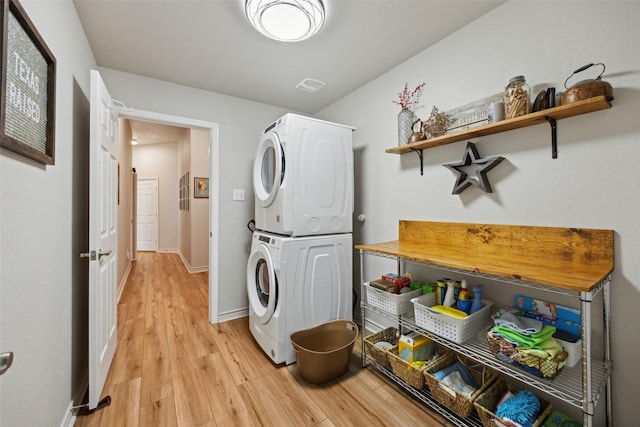 1608 Fallingwater Trl, Fort Worth, TX 76052 - laundry area featuring stacked washing machine and dryer, light wood finished floors, and baseboards